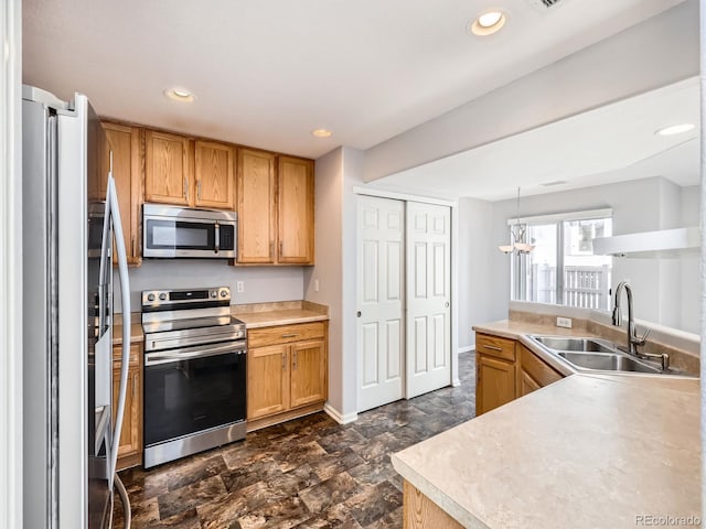 kitchen with kitchen peninsula, stainless steel appliances, hanging light fixtures, and sink