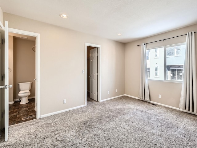 unfurnished bedroom featuring connected bathroom and carpet floors