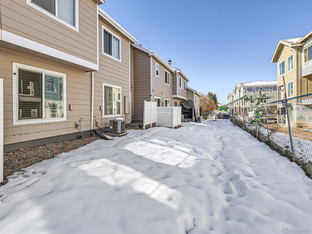 yard layered in snow with central air condition unit