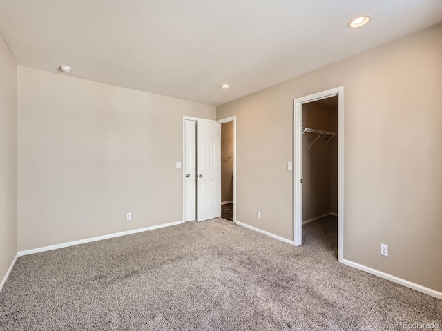 5888 Biscay St Unit D, Denver, CO 80249 - unfurnished bedroom with a spacious closet, carpet, baseboards, and recessed lighting