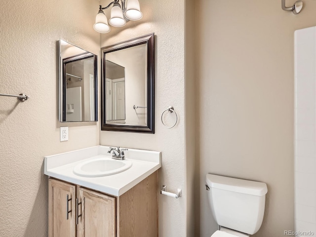 5888 Biscay St Unit D, Denver, CO 80249 - bathroom with toilet, vanity, and a chandelier