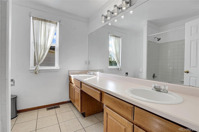 bathroom featuring tiled shower, vanity, and tile patterned flooring