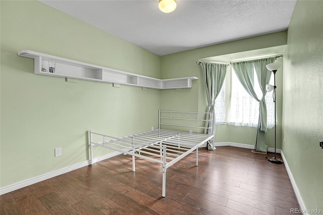 unfurnished bedroom with dark hardwood / wood-style floors and a textured ceiling