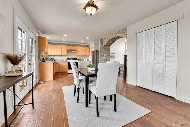 21455 E 44th Ave, Denver, CO 80249 - dining room with recessed lighting, arched walkways, baseboards, and light wood-type flooring