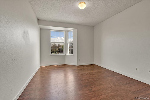 21455 E 44th Ave, Denver, CO 80249 - empty room featuring baseboards, a textured ceiling, and wood finished floors