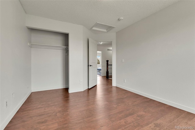 21455 E 44th Ave, Denver, CO 80249 - unfurnished bedroom featuring a textured ceiling, attic access, baseboards, wood finished floors, and a closet