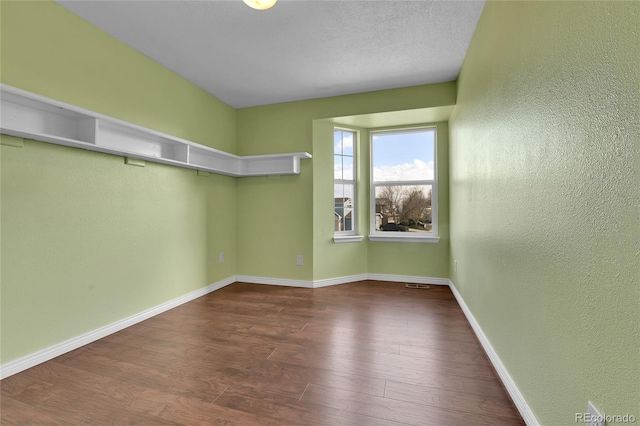 21455 E 44th Ave, Denver, CO 80249 - spare room featuring baseboards, a textured wall, and wood finished floors