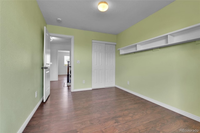 21455 E 44th Ave, Denver, CO 80249 - unfurnished bedroom featuring dark wood-style flooring, baseboards, and a closet