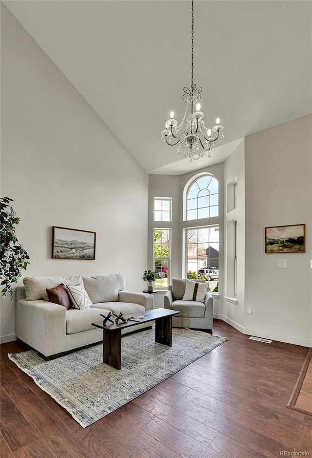 21455 E 44th Ave, Denver, CO 80249 - living area featuring high vaulted ceiling, baseboards, a notable chandelier, and dark wood-type flooring