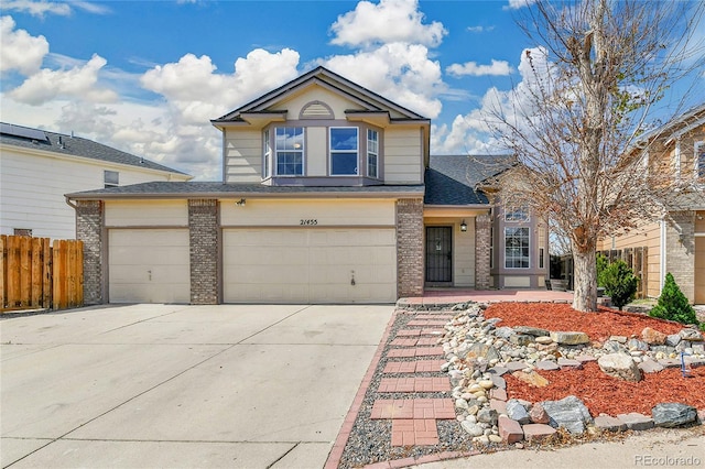21455 E 44th Ave, Denver, CO 80249 - traditional-style house with a garage, brick siding, fence, concrete driveway, and a shingled roof