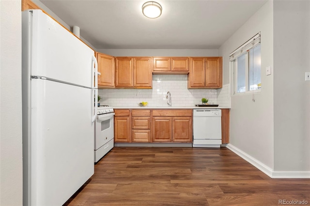 kitchen with sink, white appliances, tasteful backsplash, and dark hardwood / wood-style floors