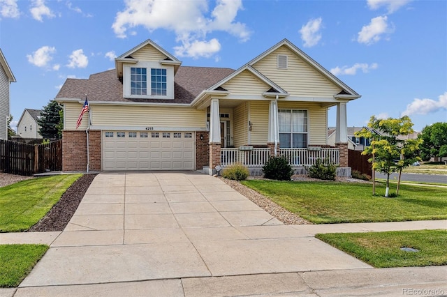 4293 Clover Ln, Brighton, CO 80601 - craftsman house with a porch, driveway, brick siding, and a shingled roof