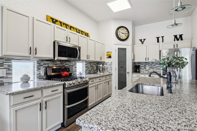 4293 Clover Ln, Brighton, CO 80601 - kitchen featuring stainless steel appliances, a sink, tasteful backsplash, and white cabinets