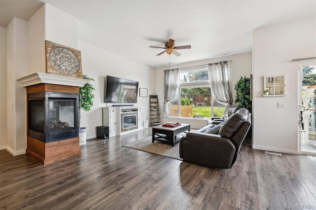 4293 Clover Ln, Brighton, CO 80601 - living room with a multi sided fireplace, a ceiling fan, wood finished floors, and baseboards