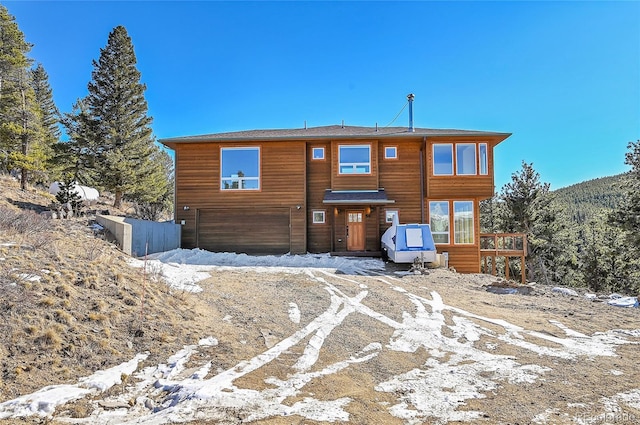 snow covered property with a garage