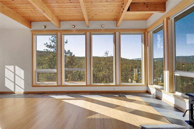 unfurnished sunroom featuring wooden ceiling and beamed ceiling