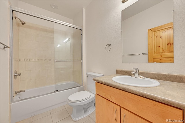 full bathroom featuring toilet, combined bath / shower with glass door, tile patterned floors, and vanity