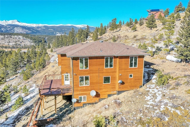 rear view of property featuring a deck with mountain view