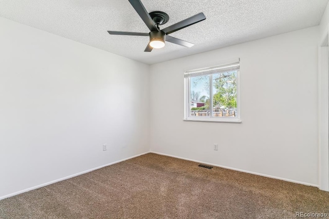 empty room featuring ceiling fan, a textured ceiling, carpet, baseboards, and visible vents