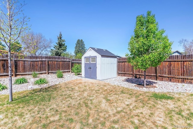 view of yard featuring a fenced backyard, an outbuilding, and a storage shed