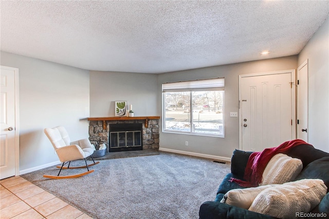 living area featuring tile patterned flooring, a fireplace, baseboards, and a textured ceiling