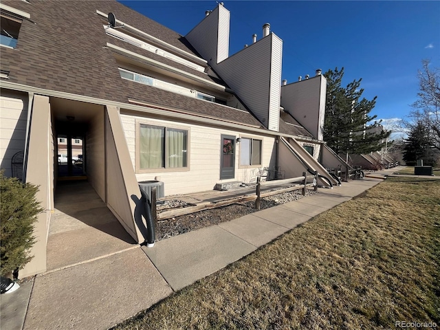 rear view of house with a shingled roof