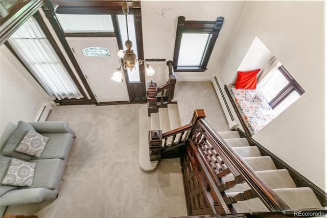 carpeted living room featuring a towering ceiling and a wealth of natural light