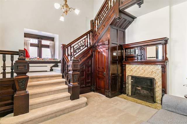 staircase featuring an inviting chandelier, carpet floors, and a high ceiling