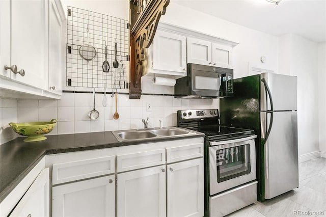 kitchen with stainless steel appliances, sink, light tile patterned floors, white cabinets, and tasteful backsplash