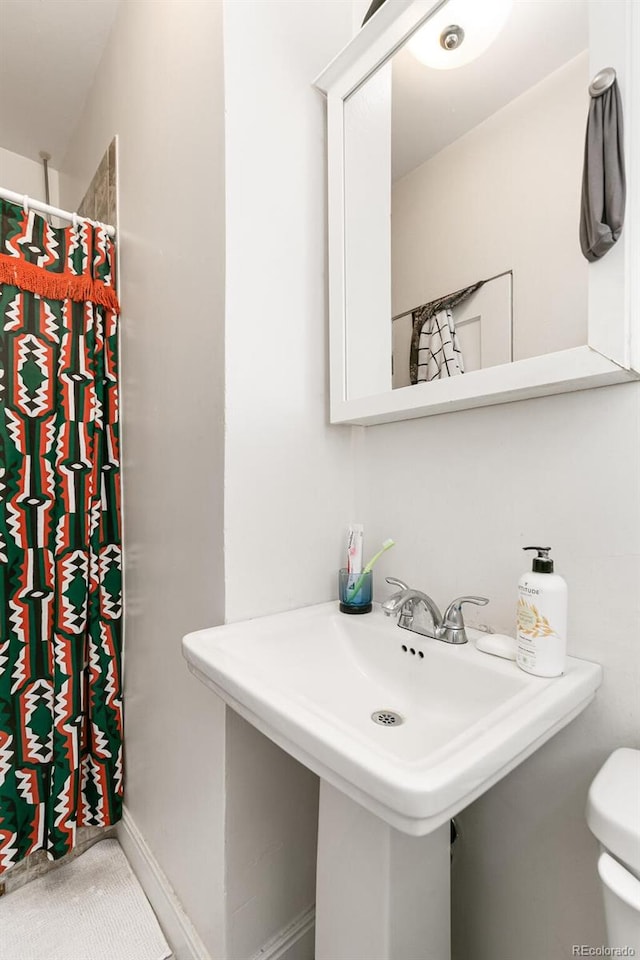 bathroom featuring curtained shower and toilet