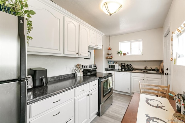 kitchen featuring sink, white cabinets, stainless steel appliances, and light hardwood / wood-style floors