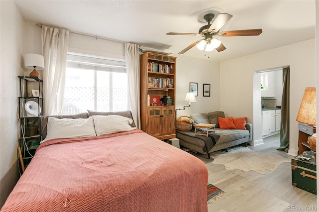 bedroom featuring ensuite bath, wood-type flooring, and ceiling fan