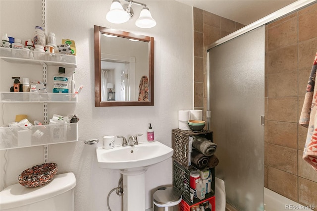 bathroom featuring toilet and an enclosed shower