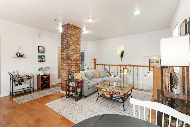 living room with decorative columns and light wood-type flooring