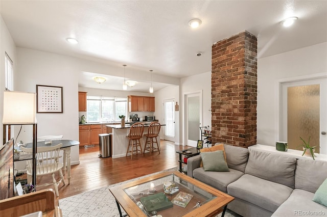 living room with decorative columns and light wood-type flooring