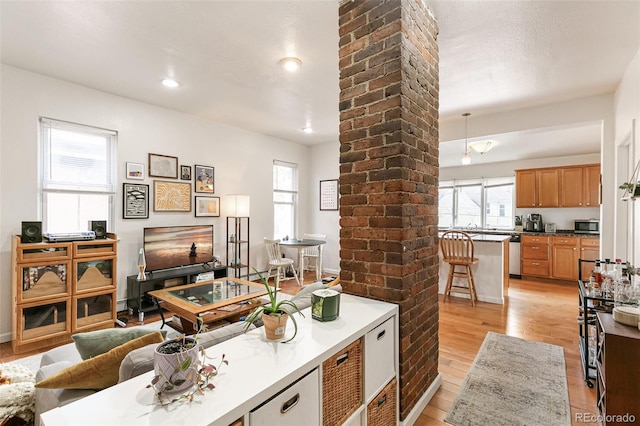 interior space with light hardwood / wood-style floors and ornate columns