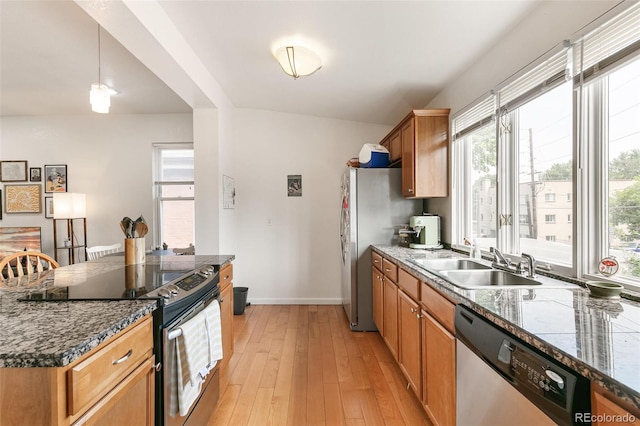 kitchen featuring sink, light hardwood / wood-style floors, stainless steel appliances, vaulted ceiling, and pendant lighting