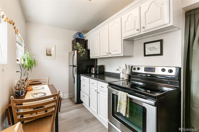 kitchen with appliances with stainless steel finishes, light wood-type flooring, and white cabinets