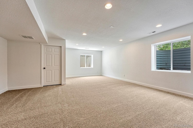 carpeted spare room featuring a textured ceiling