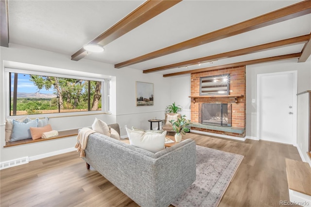 7055 S Costilla St, Littleton, CO 80120 - living area with beam ceiling, a brick fireplace, and wood finished floors