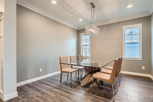 dining space featuring dark hardwood / wood-style flooring, crown molding, and an inviting chandelier