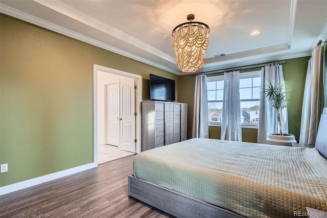 bedroom with a raised ceiling, crown molding, a chandelier, and wood-type flooring