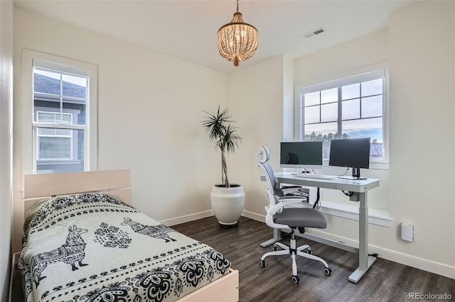 bedroom featuring dark hardwood / wood-style flooring, an inviting chandelier, and multiple windows