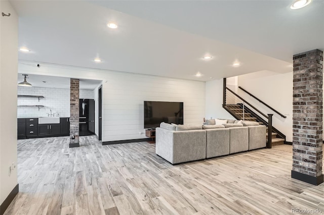 living room with light hardwood / wood-style floors and sink