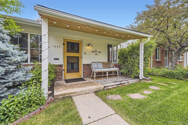 1292 Kearney St, Denver, CO 80220 - entrance to property featuring covered porch, brick siding, and a yard