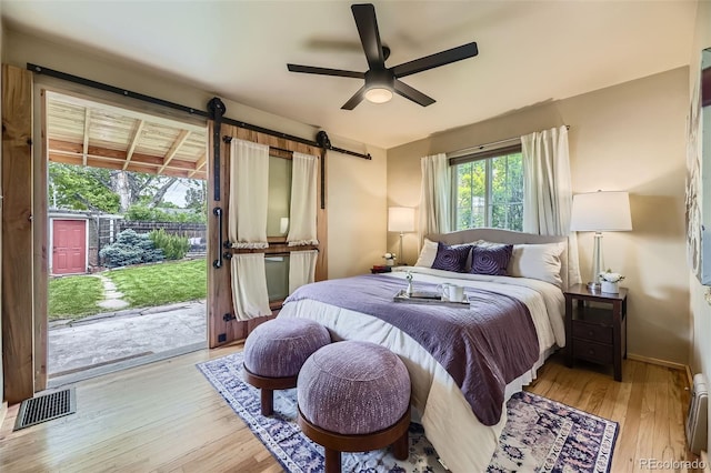 1292 Kearney St, Denver, CO 80220 - bedroom with access to exterior, light wood-style floors, a barn door, baseboards, and a baseboard radiator