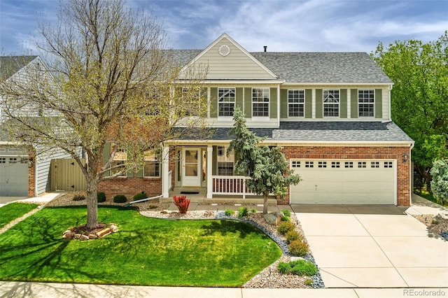 view of front of property with roof with shingles, a front lawn, brick siding, concrete driveway, and covered porch