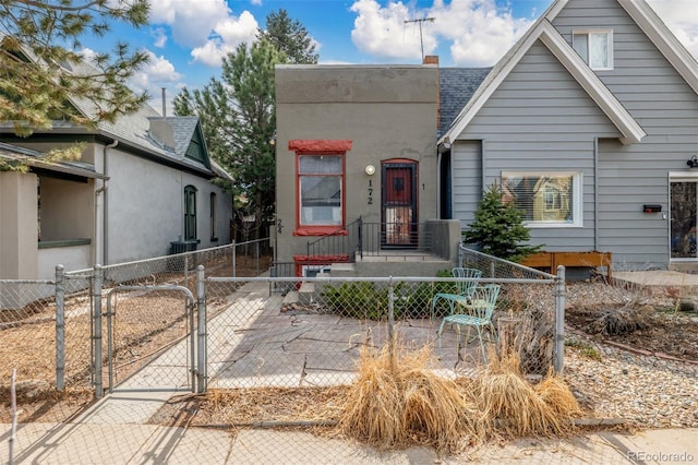 view of front of property with a shingled roof, a gate, a fenced front yard, and a chimney