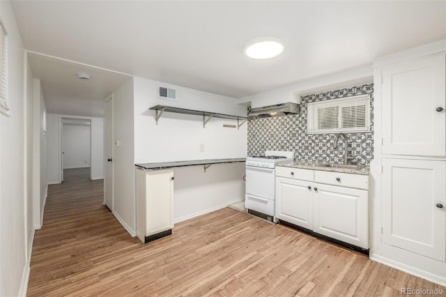 kitchen featuring visible vents, a sink, open shelves, under cabinet range hood, and white range with gas stovetop