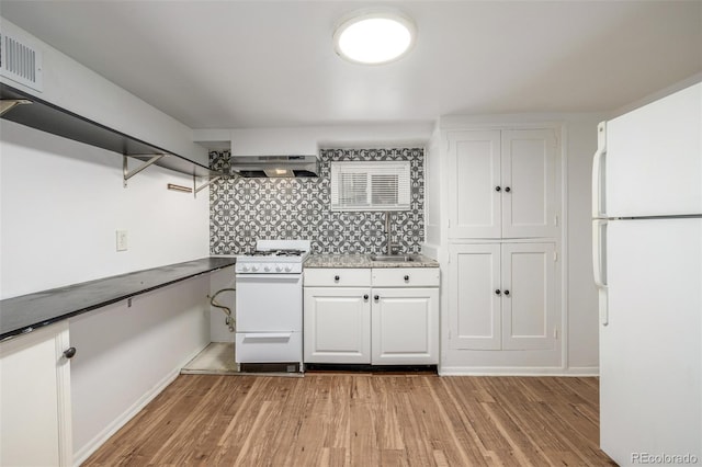 kitchen featuring tasteful backsplash, light wood-style flooring, exhaust hood, white cabinets, and white appliances